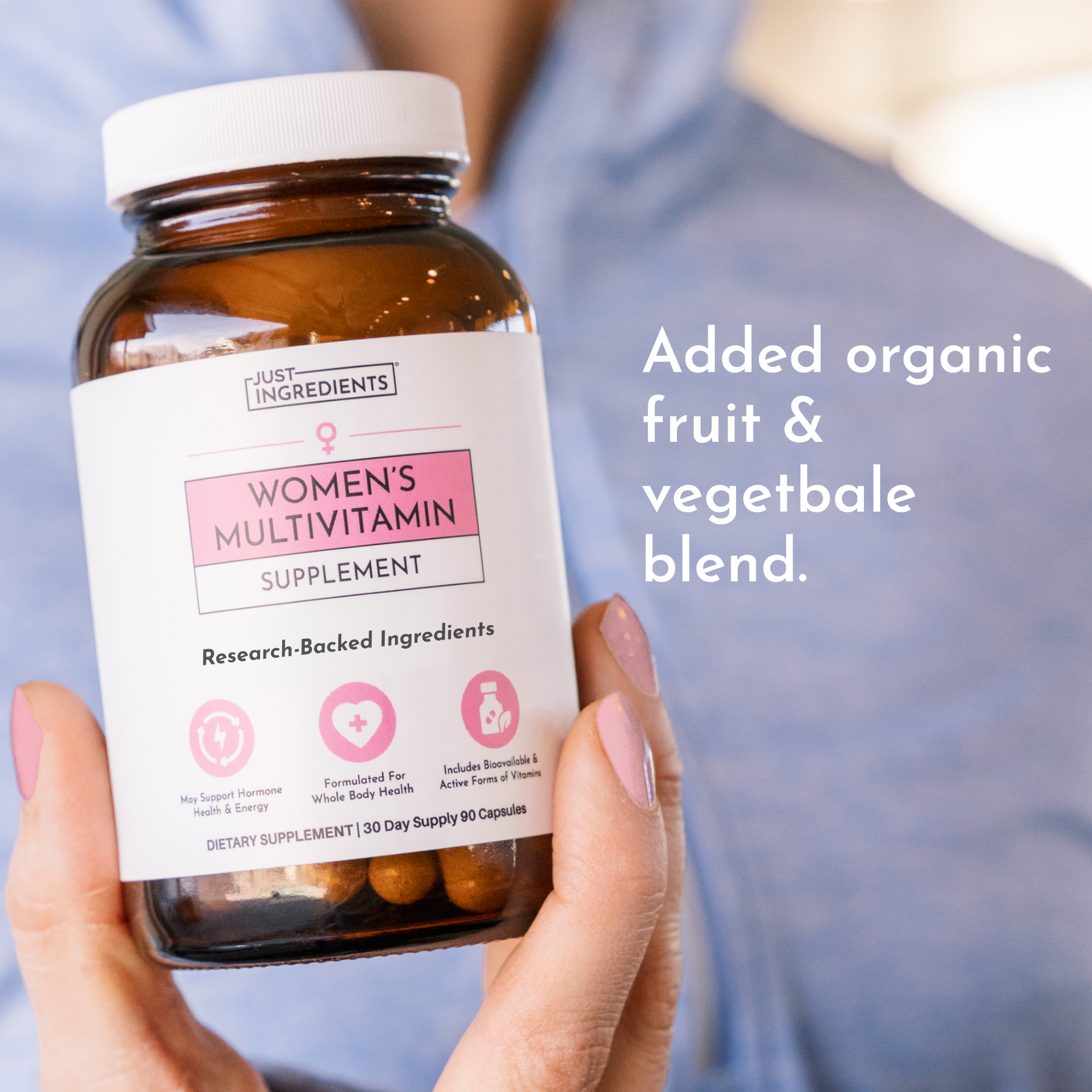 Hand holding amber glass bottle of women's multivitamin supplement with white label and 90 capsules.