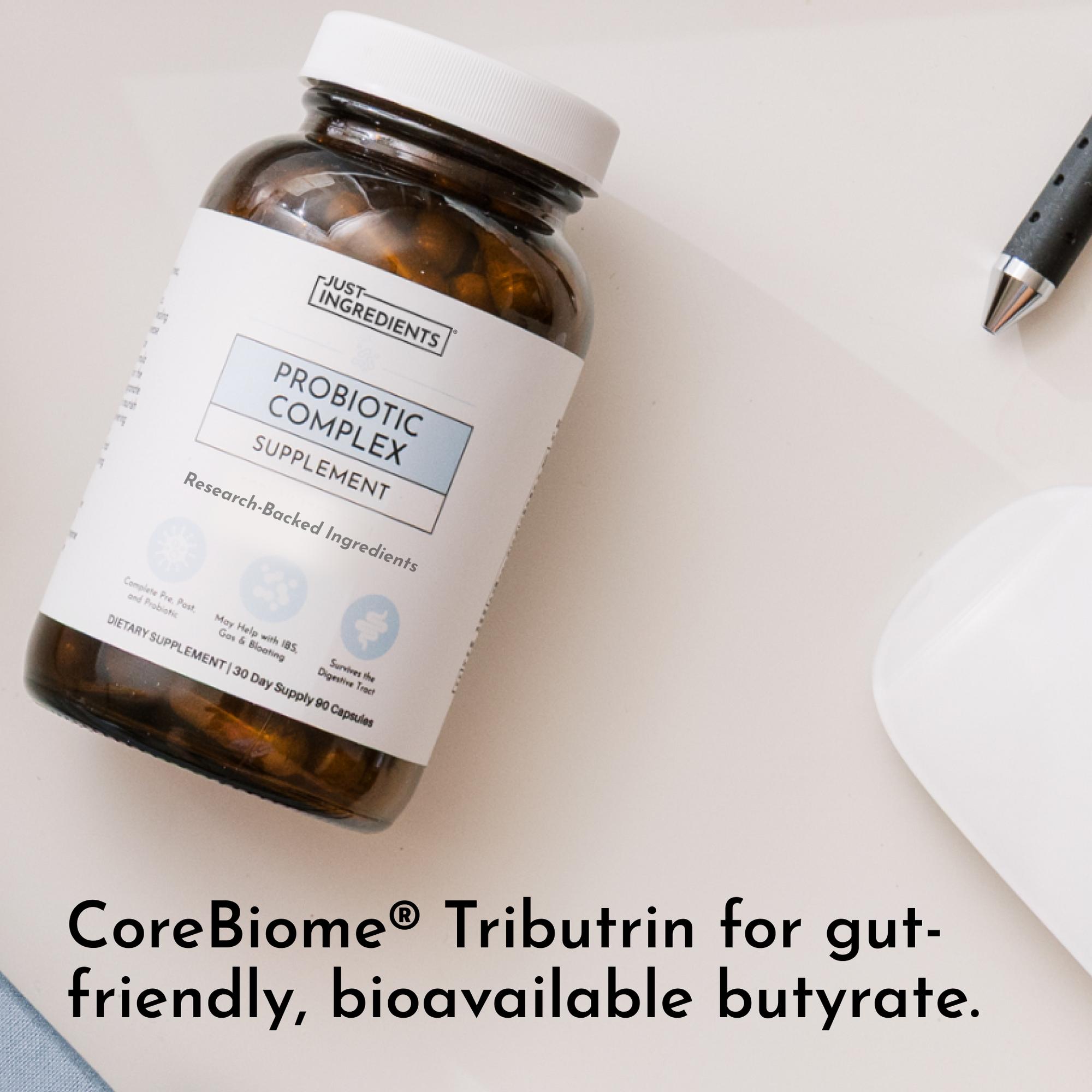 Amber glass bottle with white cap and label reading "Just Ingredients Probiotic Complex Supplement" containing capsules.