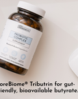 Amber glass bottle with white cap and label reading "Just Ingredients Probiotic Complex Supplement" containing capsules.