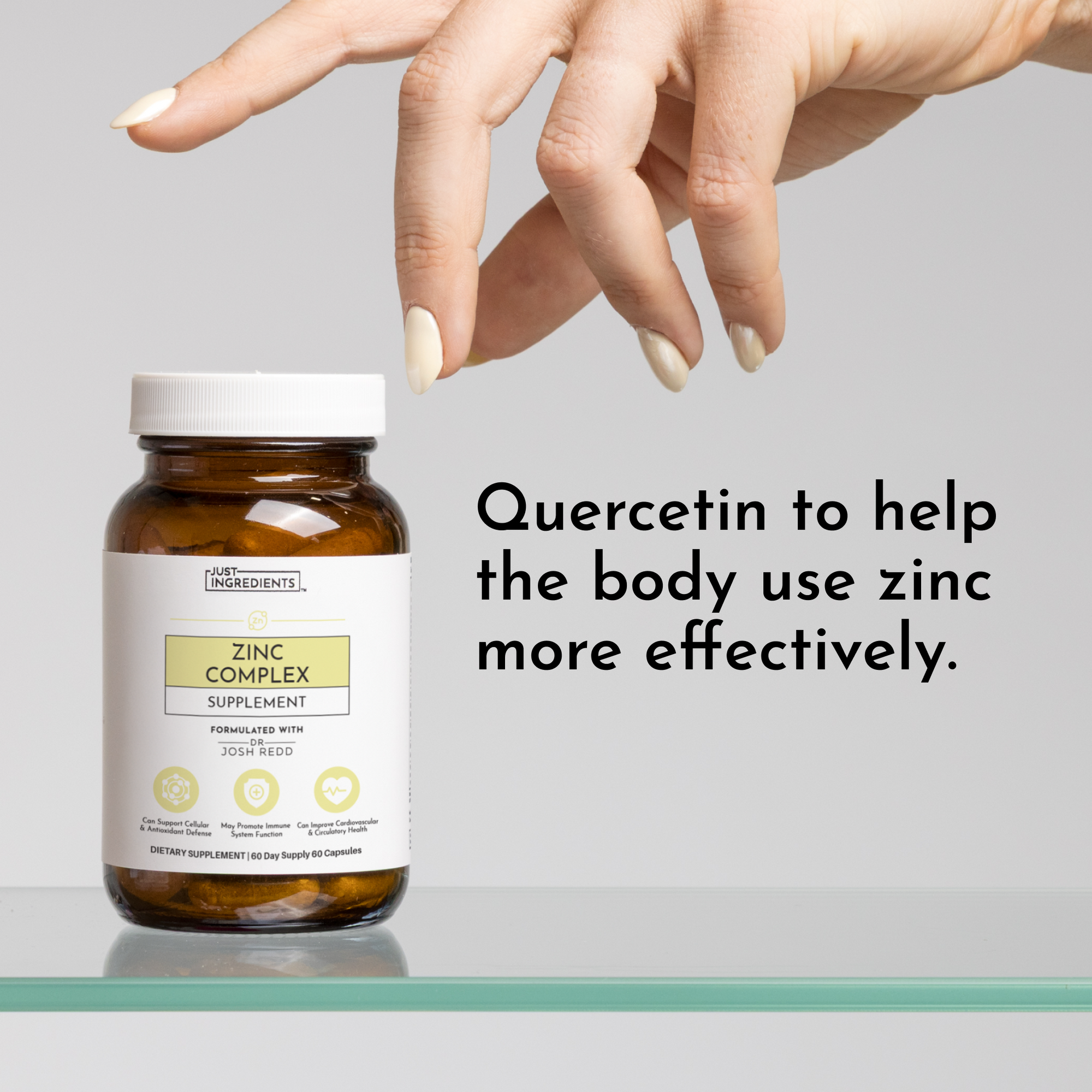 Brown bottle of Zinc Complex supplement with a white lid, placed on a glass surface, with a hand reaching towards it.