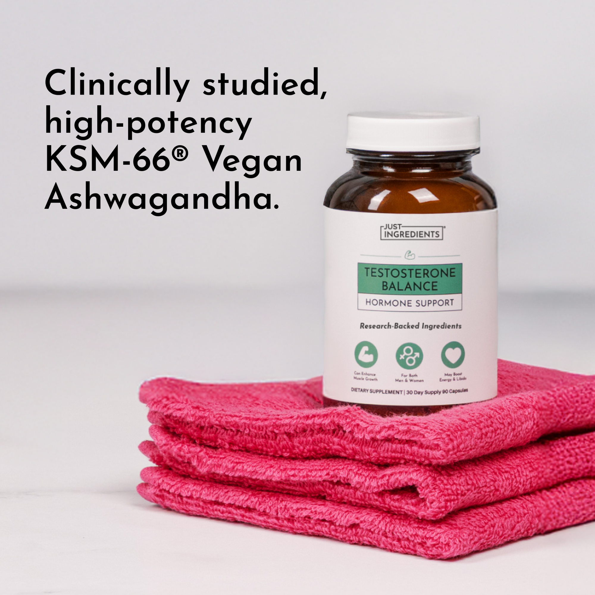 Brown glass bottle labeled "Testosterone Balance Hormone Support" sitting on stacked pink towels.