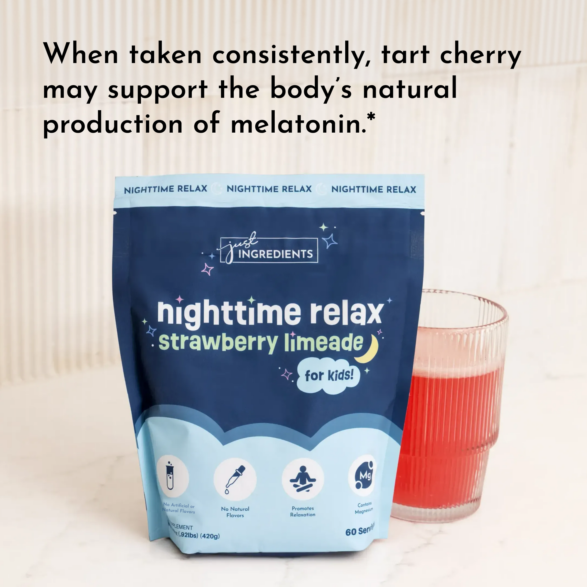 Dark blue pouch of strawberry limeade nighttime relax powder for kids next to a glass of red liquid.