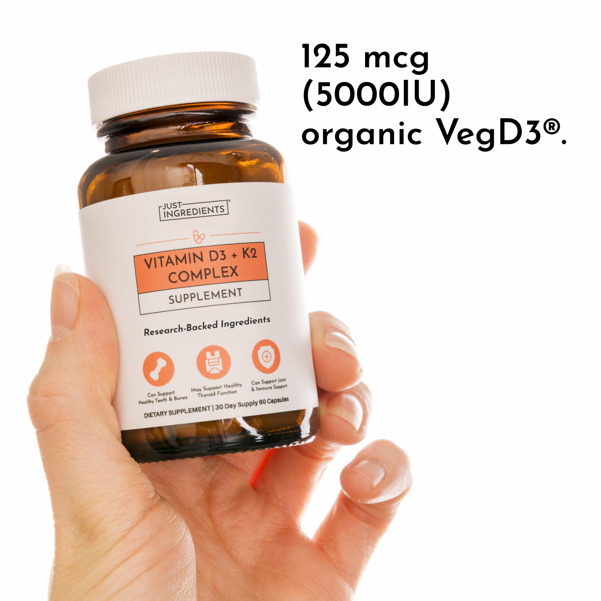Brown glass bottle of Vitamin D3 + K2 Complex supplement with white label held in hand, 60 capsules, 30-day supply.