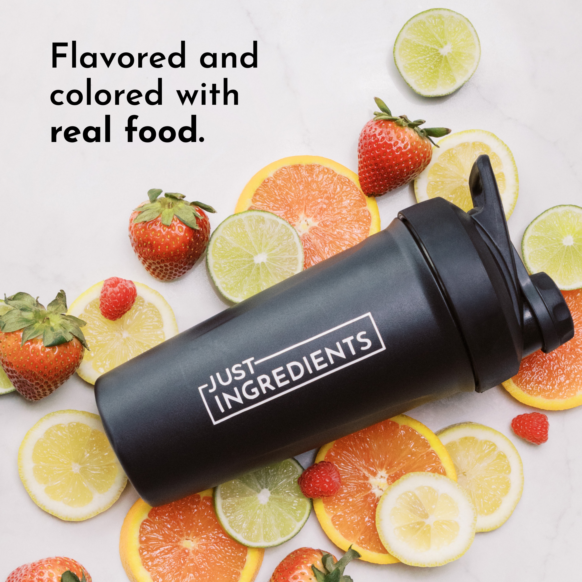 Black shaker bottle labeled JUST INGREDIENTS surrounded by citrus fruits and strawberries to indicate flavor.