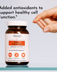 Hand holding amber glass bottle of NAD+ Complex dietary supplement capsules with white label and orange accent panel.