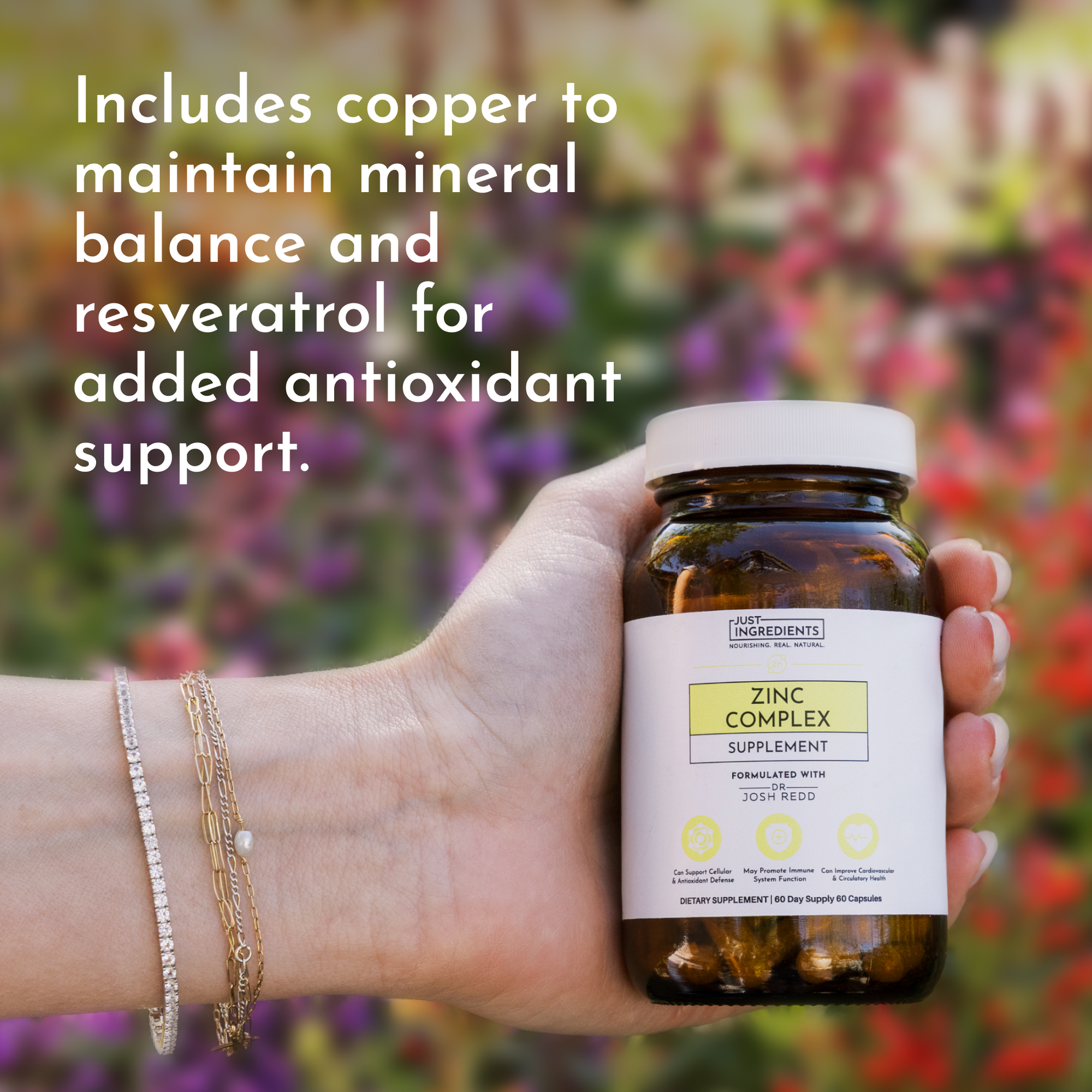 Hand holding a brown bottle labeled "Zinc Complex Supplement" with a white cap and surrounded by colorful flowers.