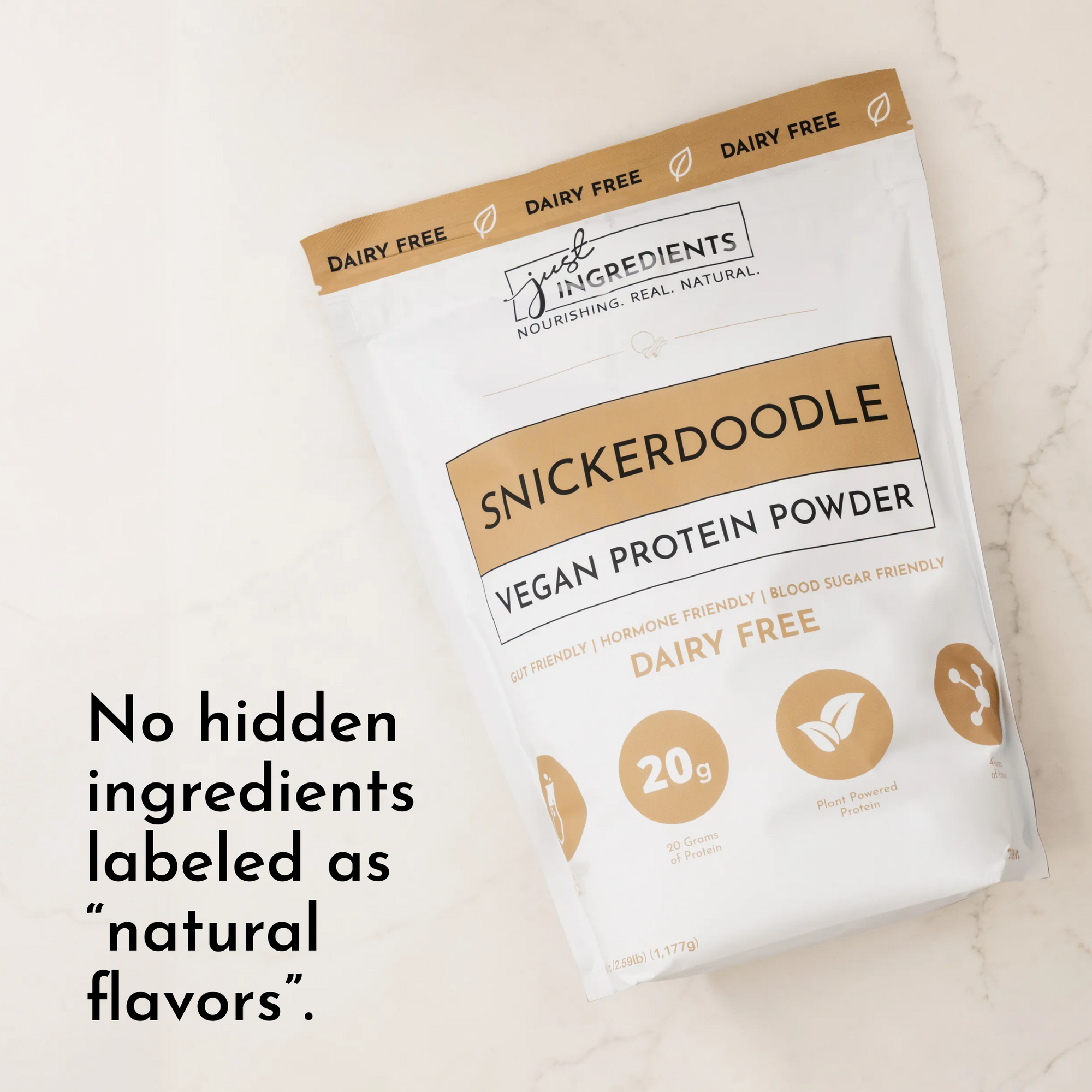 White pouch of Snickerdoodle vegan protein powder with gold accents and text highlighting its dairy-free and ingredient trans