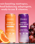 Two energy drink cans, one orange labeled "Orange Fizz" and one purple labeled "Grape Soda," with fresh fruit beside them.