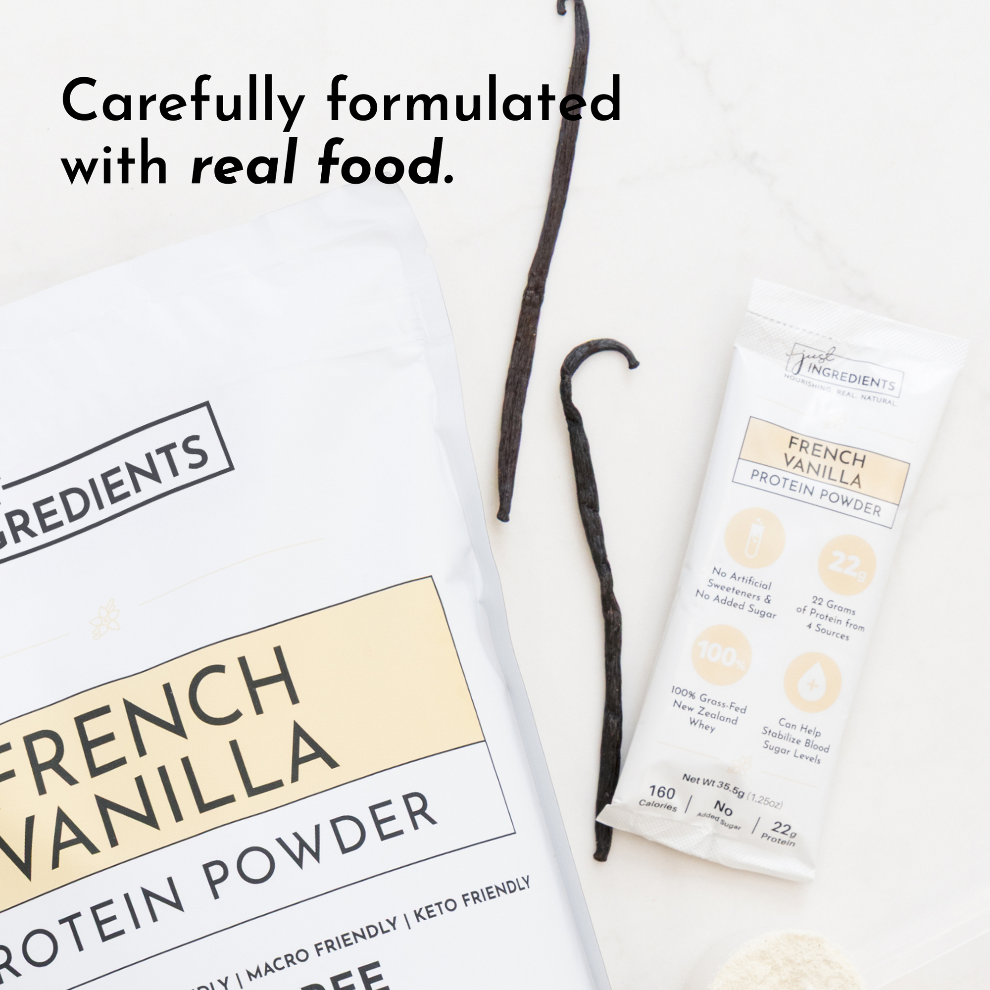 White packaging of French Vanilla protein powder with a stick pack and vanilla beans on a light surface.
