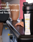Black shaker bottle with a Tropical Paradise Pre-Workout stick displayed on a gym bench, weights in the background.