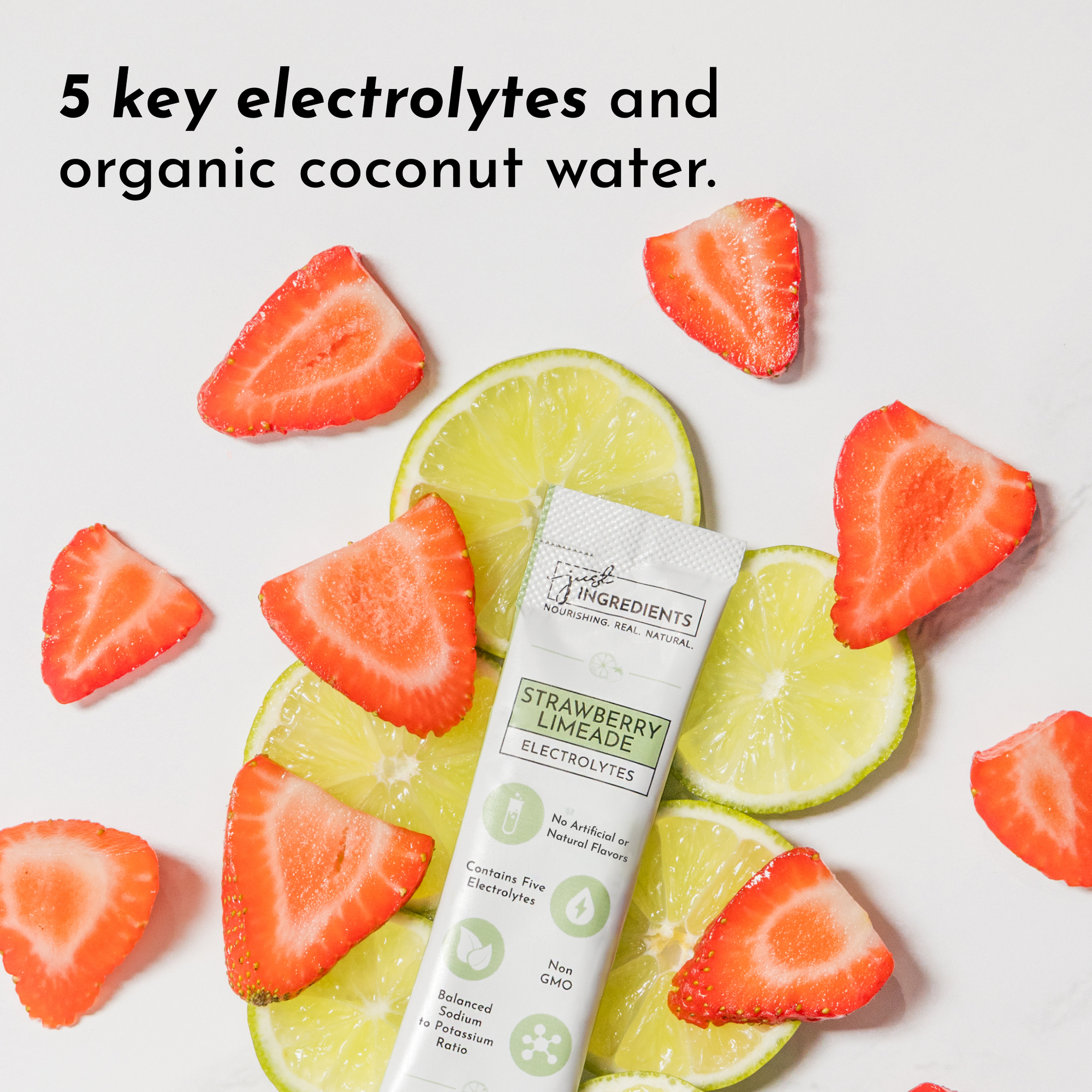 Electrolyte stick surrounded by sliced strawberries and lime, featuring a green and silver packaging.