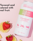 Clear protein drink can featuring strawberry limeade flavor, surrounded by fresh strawberries and lemon slices.