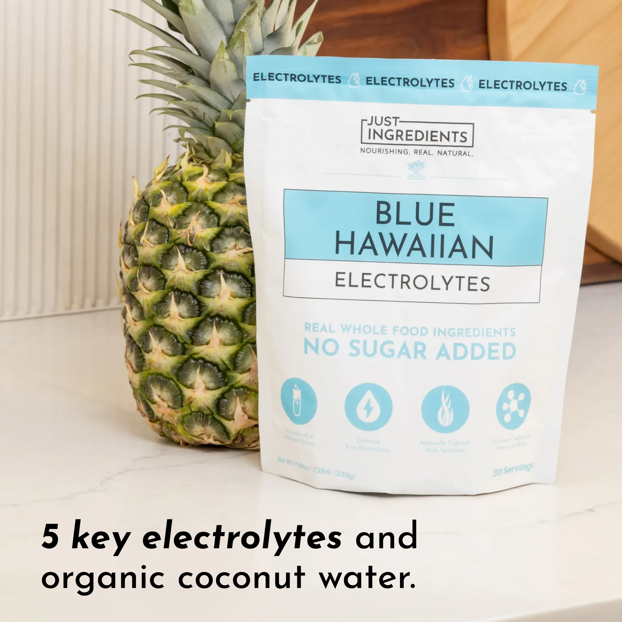 Pouch of Blue Hawaiian Electrolytes next to a pineapple, featuring details about ingredients and servings.