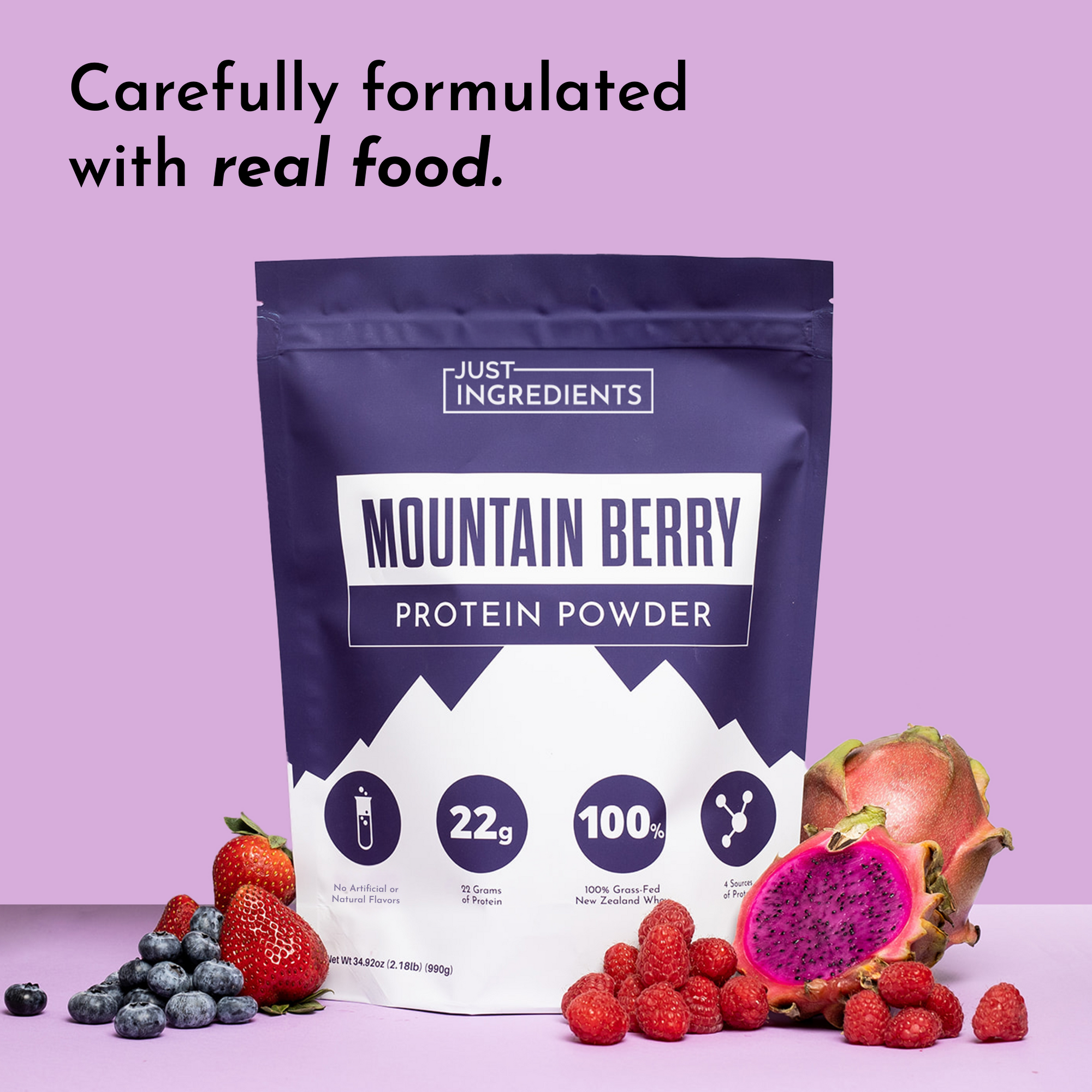 Purple packaging of Mountain Berry Protein Powder with berries and a dragon fruit on a pink background.