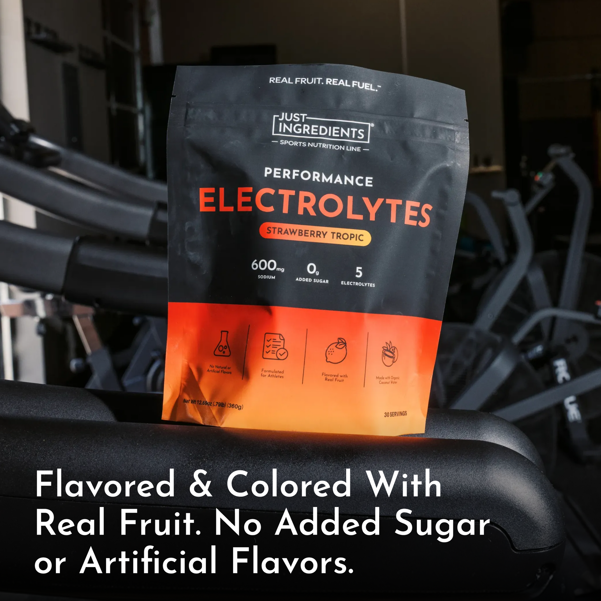 Black and orange pouch of Strawberry Tropic Performance Electrolytes with nutrition facts displayed on dark background near e