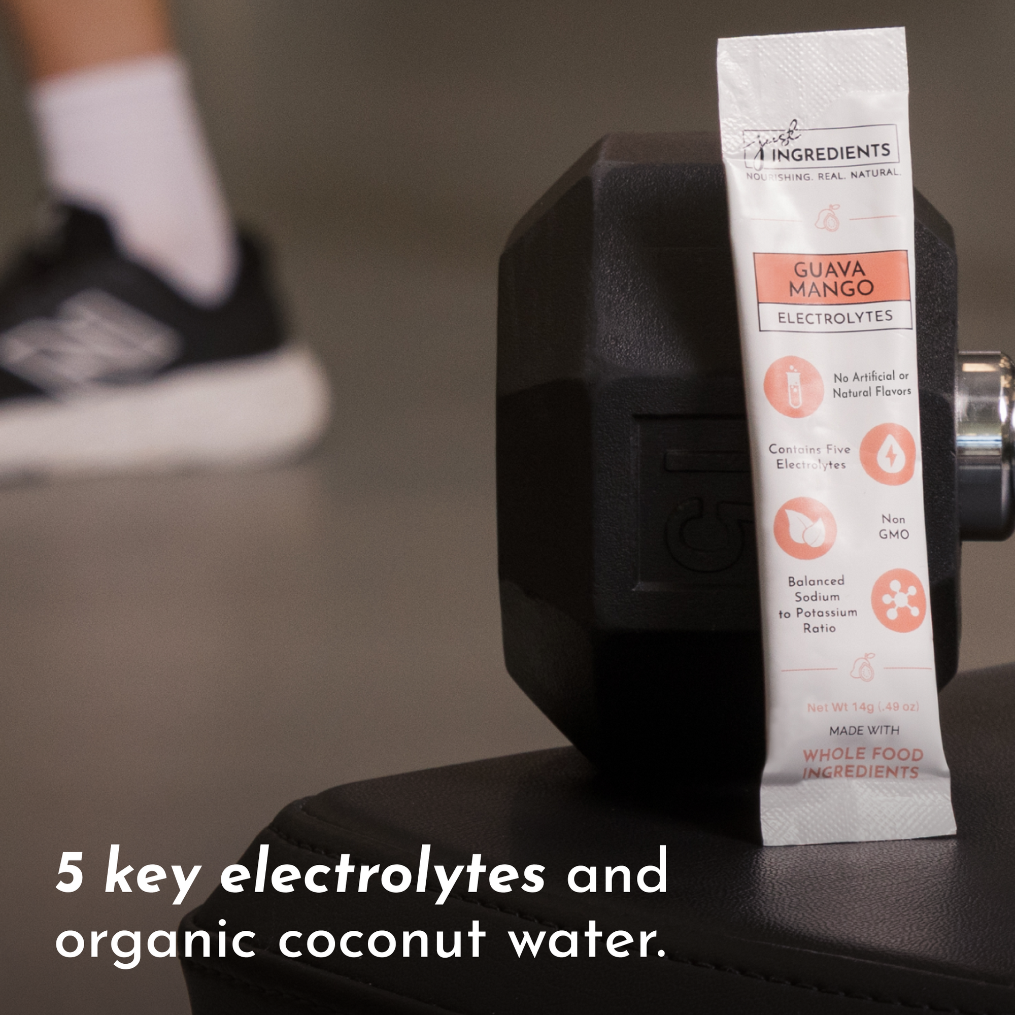 Electrolyte stick packet resting on a dumbbell, with text highlighting key features and ingredients.
