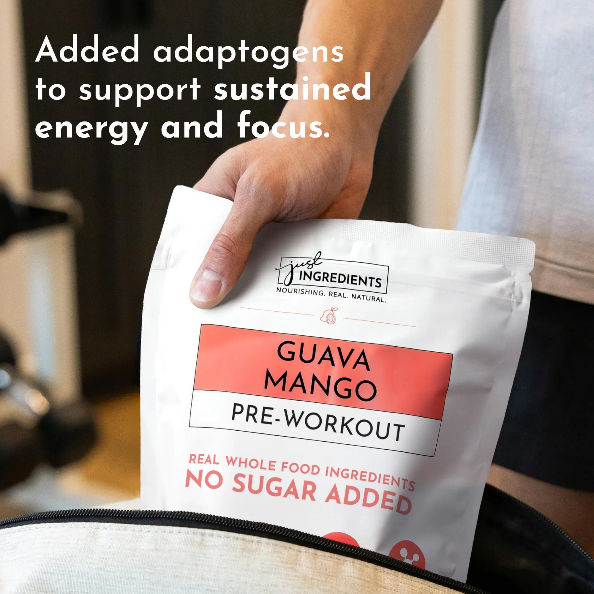 Hand holding white packet labeled "Guava Mango Pre-Workout" with red accent stripe and "Just Ingredients" branding.