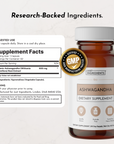 Amber glass bottle of ashwagandha dietary supplement capsules with white cap and product label showing ingredients and GMP ce