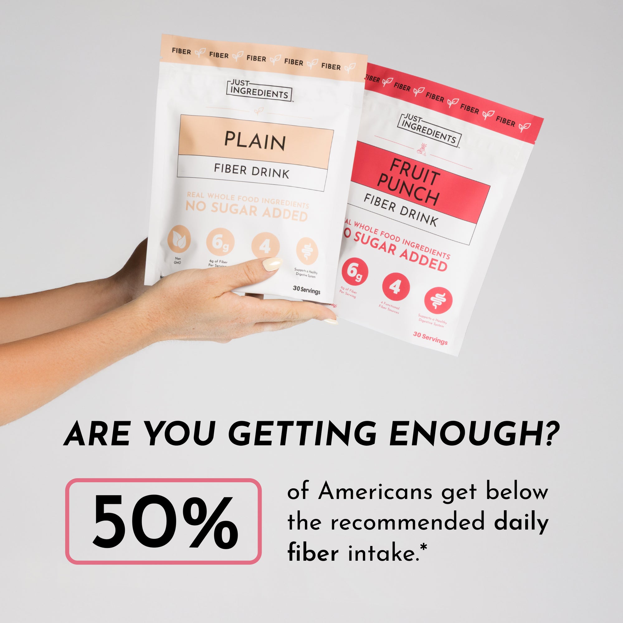 Two fiber drink packets held in hands, labeled "Plain" and "Fruit Punch," with a neutral background.
