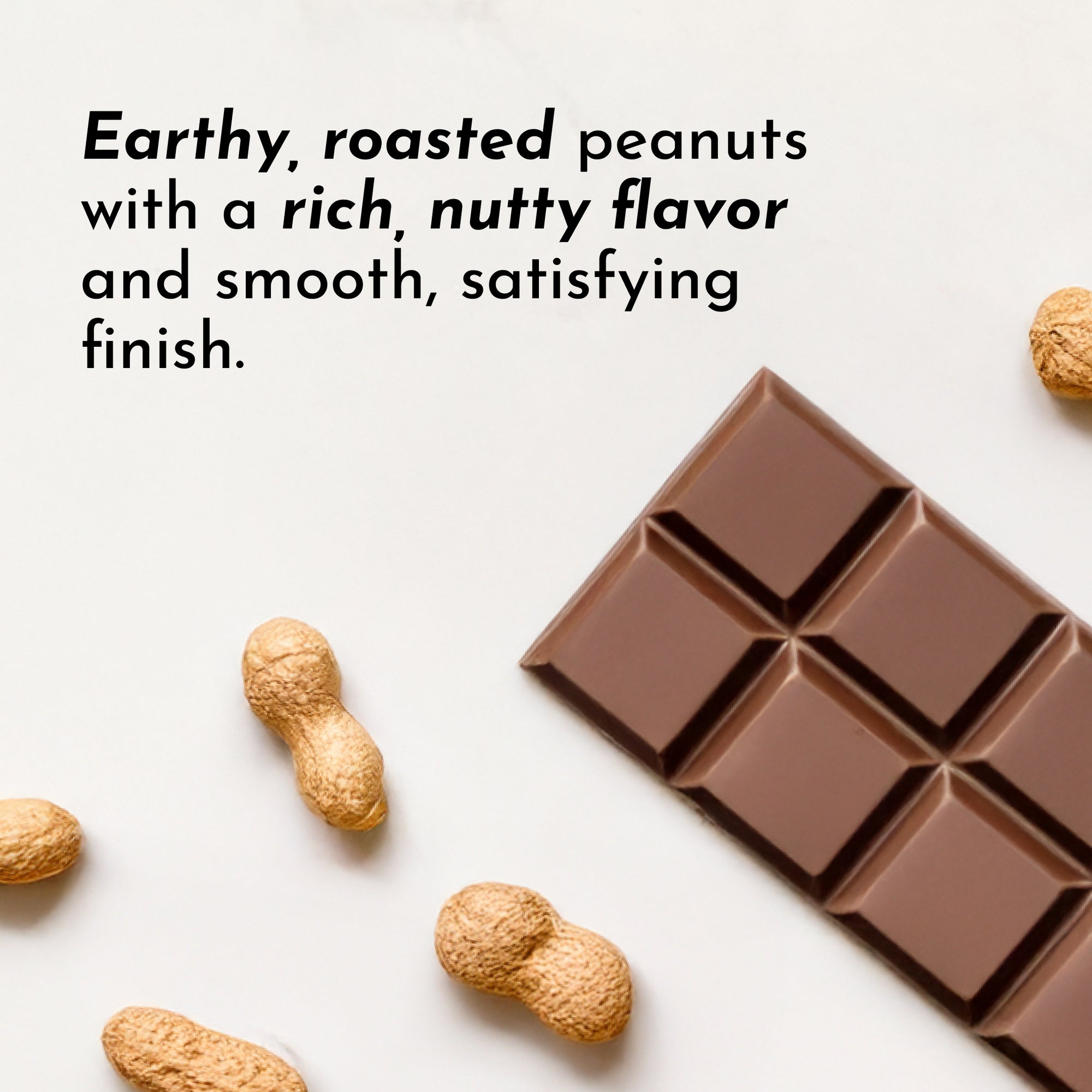 Peanuts and a chocolate protein bar are displayed on a light surface.