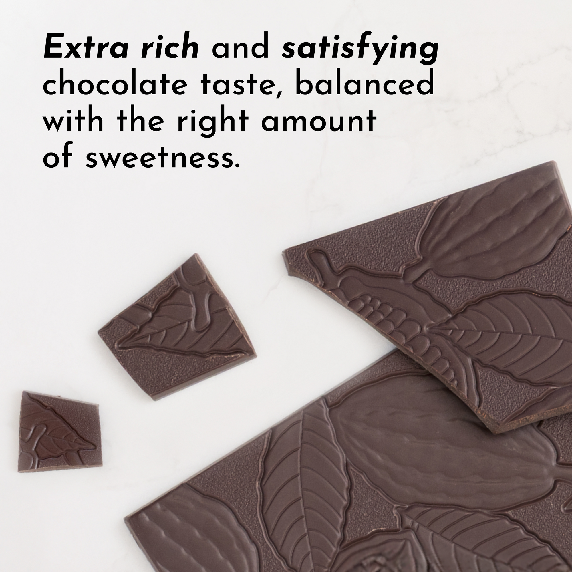 Dark chocolate pieces with a textured design, some broken into smaller segments on a white surface.