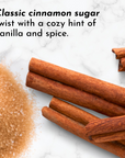 Cinnamon sticks and cinnamon sugar mixture on marble surface.