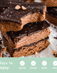 Stack of chocolate-covered protein bars with a bite taken out, sprinkled with nuts and sea salt.