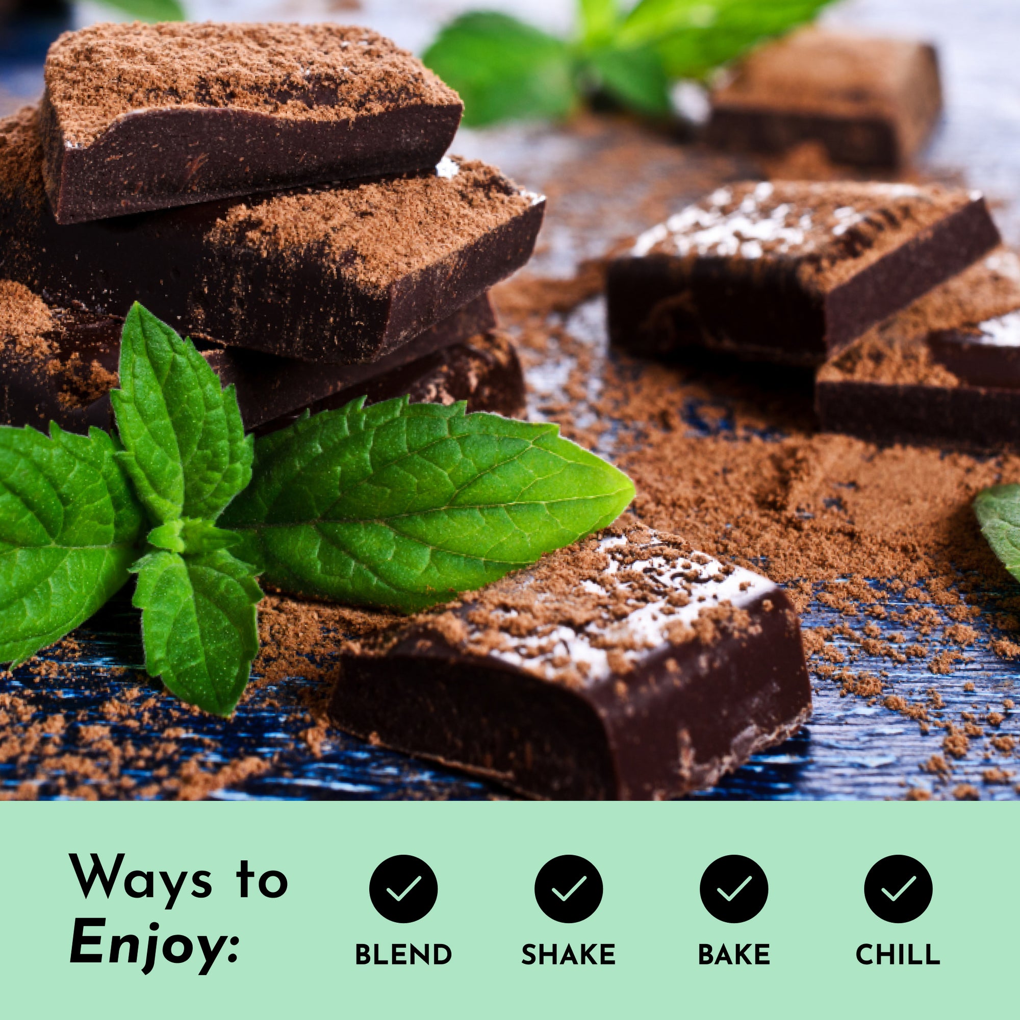 Dark chocolate pieces are scattered with cocoa powder and fresh mint leaves on a wooden surface.