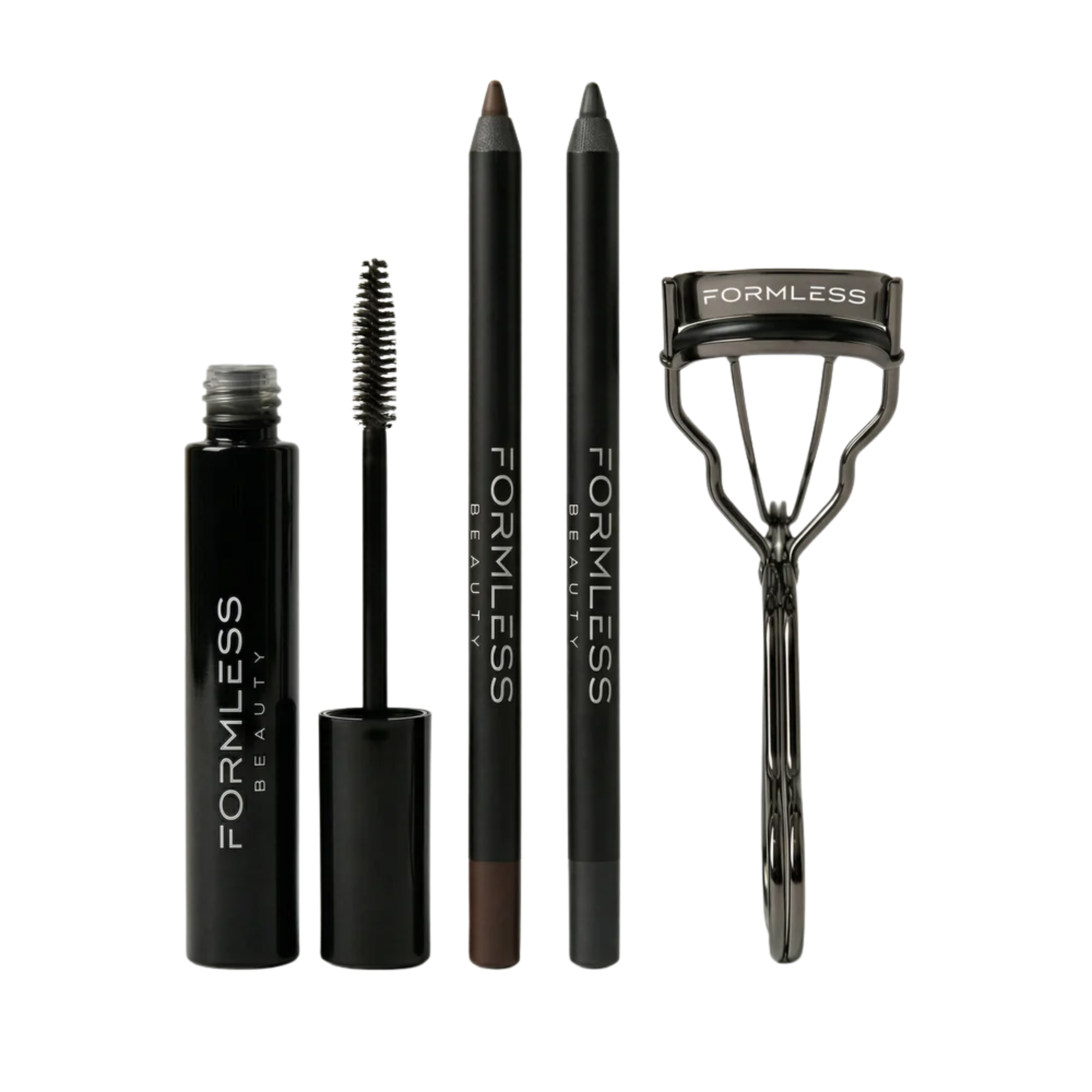 white background with black eye liner pencils, eyelash curler, and mascara