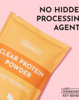 Clear protein powder packaging in orange with "Orange Creamsicle" flavor and 21g protein per serving.