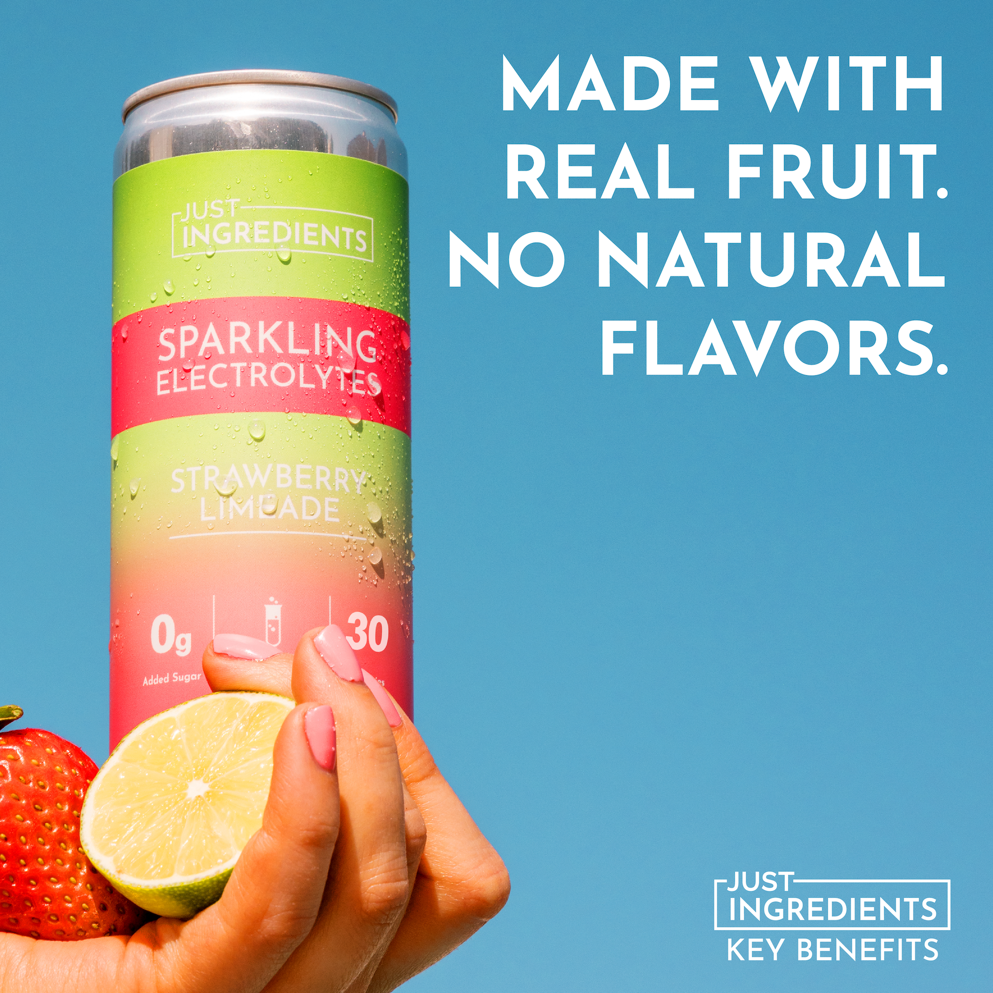 Can of Strawberry Limeade Sparkling Electrolytes held in hand, with a strawberry and lime in the foreground.