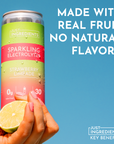 Can of Strawberry Limeade Sparkling Electrolytes held in hand, with a strawberry and lime in the foreground.