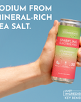 Hand holding a can of Strawberry Limeade Sparkling Electrolytes against a blue background.