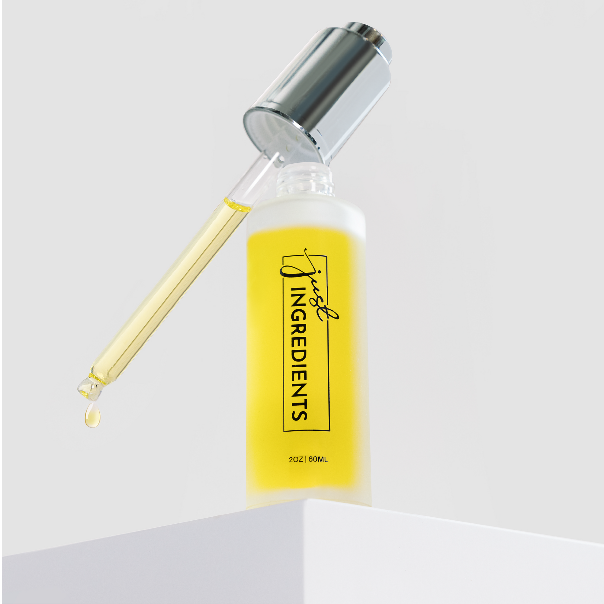 Clear glass bottle with a dropper, containing yellow face serum labeled "Just Ingredients," 2 oz (60 mL).