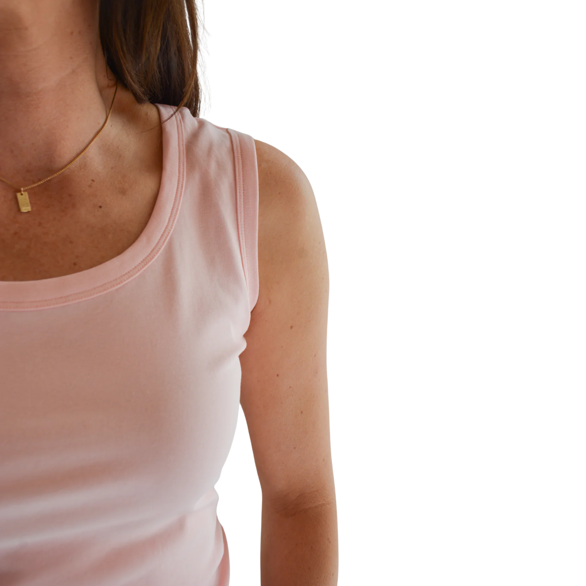 Light pink tank top with a scoop neckline and wide straps, worn by a person with shoulder-length hair.