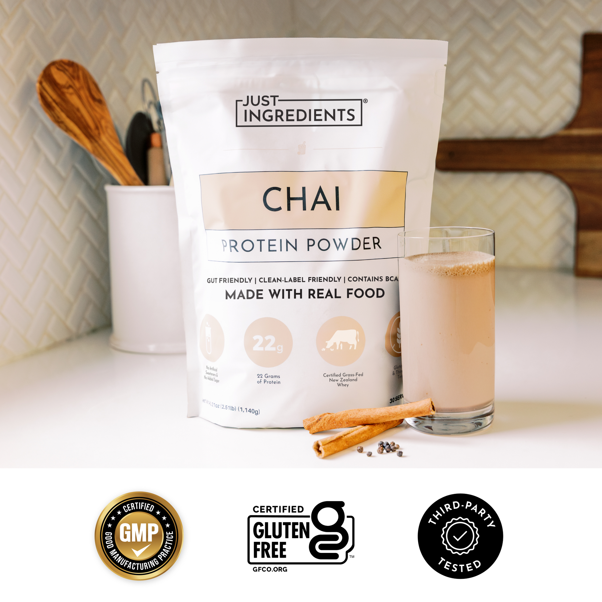 Chai Protein Powder pouch with prepared shake in a glass on a kitchen countertop.