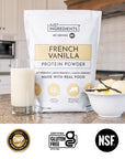 Bag of French vanilla protein powder beside a glass of milk and a vanilla bean.