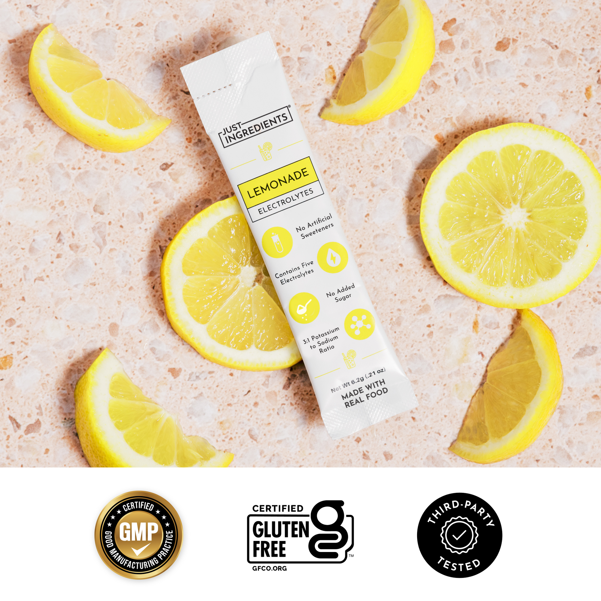 Lemonade electrolytes stick beside lemon slices on marble surface with packaging information visible