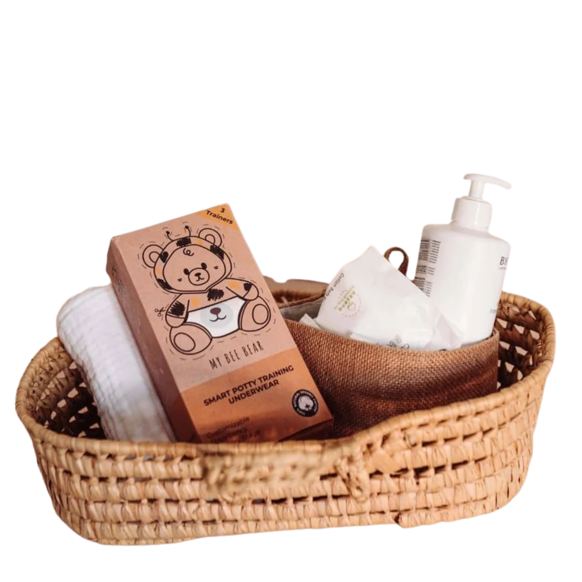 A woven brown basket with the my bee bear box with a muslin white cloth behind it and some wipes and a white pump bottle to the side