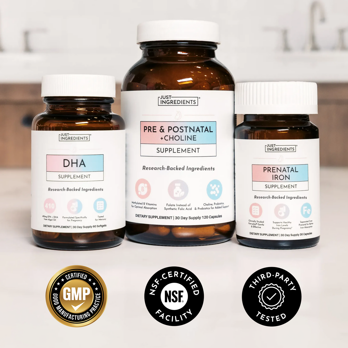 Three brown glass bottles with white caps labeled DHA Supplement, Pre &amp; Postnatal + Choline Supplement, and Prenatal Iron Sup