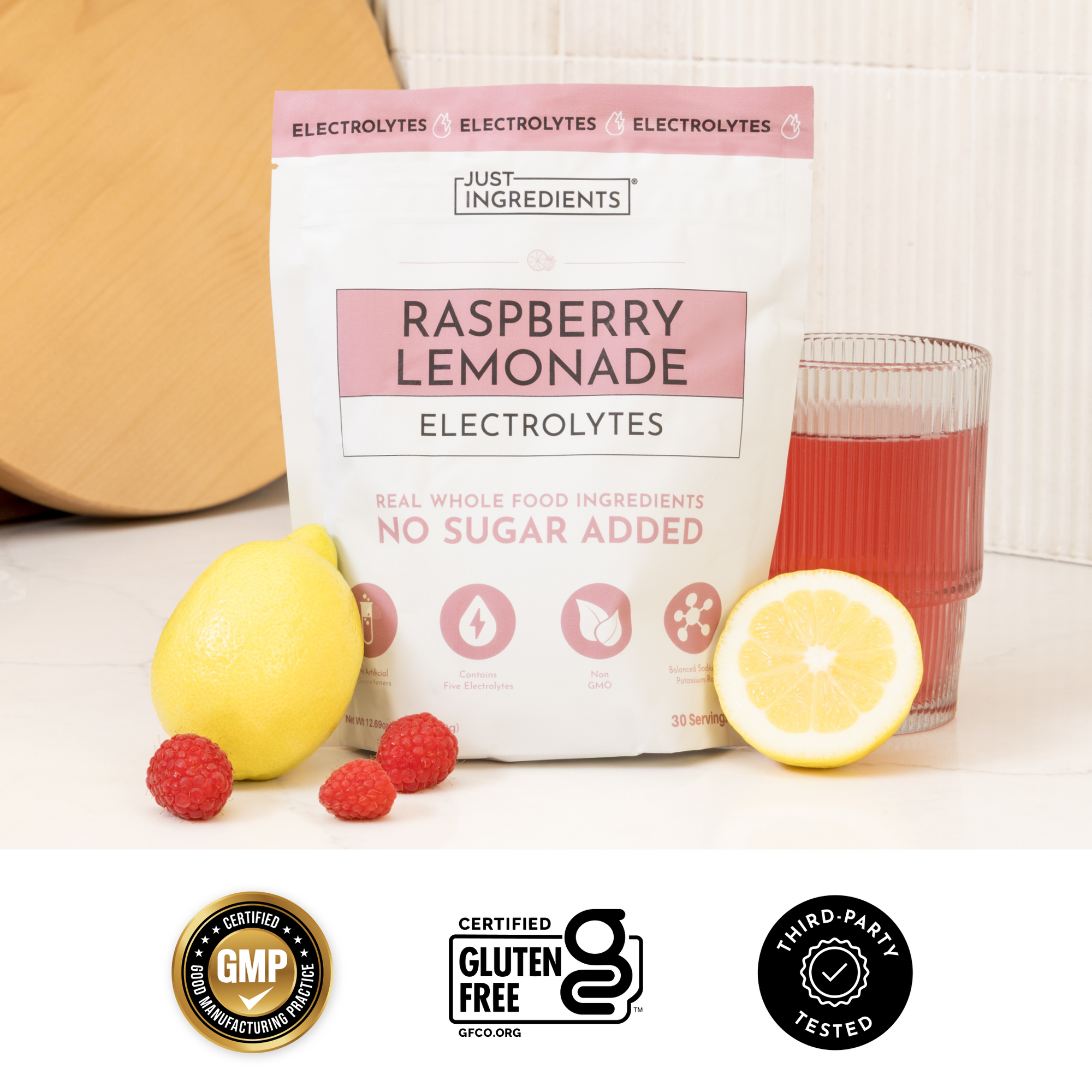 Text panel listing benefits of Raspberry Lemonade Electrolytes with colored scoops on a pink background.