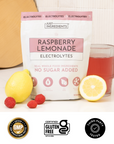 Text panel listing benefits of Raspberry Lemonade Electrolytes with colored scoops on a pink background.