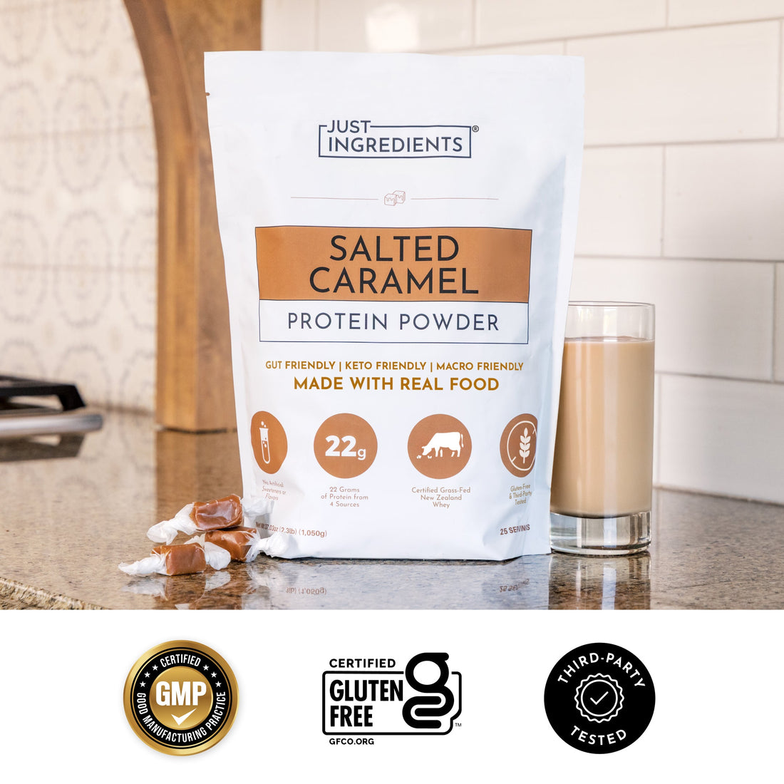 Salted caramel protein bag next to a prepared protein shake and a pink handheld mixer on a countertop.