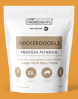 White pouch of Snickerdoodle protein powder with gold accents and nutrition panel visible.