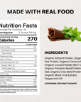 Package of mint chocolate vegan protein powder arranged with chocolate pieces and mint leaves on a pale blue background.